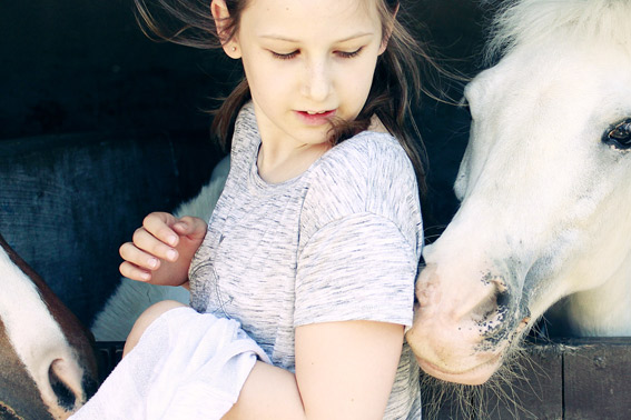 Nina con un poni en los campamentos de verano de Equus Duri